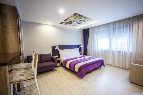 een slaapkamer met een paars bed en een paarse stoel bij Levendula Apartmanház in Sárvár
