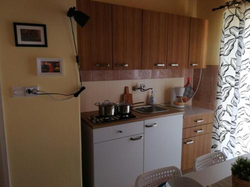 a kitchen with white cabinets and a stove top oven at Panoramic view studio in Rab