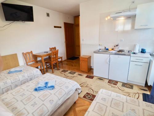 a room with two beds and a kitchen with a table at Willa Dutka in Szczawnica