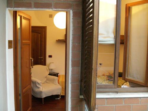 a room with a room with a chair and a mirror at Bed & Breakfast Le Coste in Massa Marittima