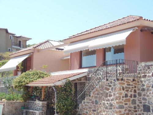 a house with a stone wall and a balcony at Eco Villa in Mákri