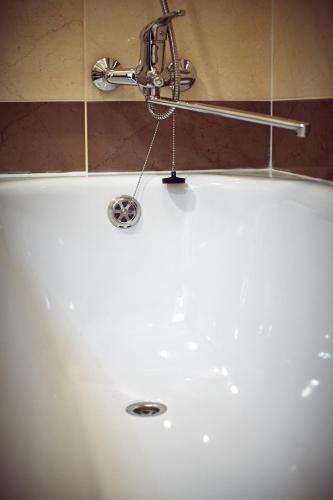 a bath tub with a water faucet in a bathroom at Babylon Apartments On Dubenska Street in Rivne