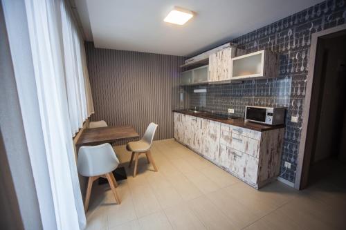 kuchnia z blatem, stołem i krzesłami w obiekcie Levendula Apartmanház w Sárvárze
