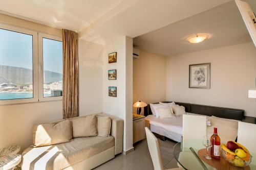 a bedroom with a bed and a table and a couch at Penthouse View HN in Herceg-Novi