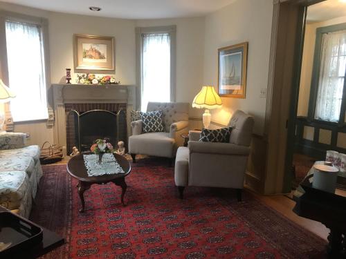 a living room with a couch and a fireplace at Parsonage Inn Bed and Breakfast in Saint Michaels
