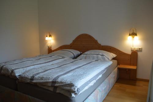 ein Bett in einem Schlafzimmer mit zwei Lichtern an der Wand in der Unterkunft Ferienwohnung Lucia in Bad Schlema