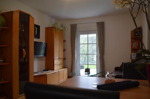 ein Wohnzimmer mit einem Tisch und einem Fenster in der Unterkunft Ferienwohnung Lucia in Bad Schlema