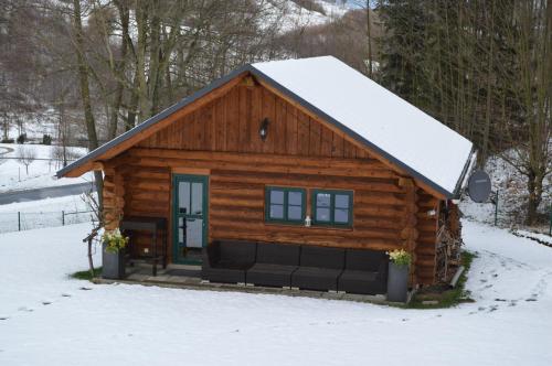 a log cabin with snow on the roof at Ferienwohnung Lucia in Bad Schlema