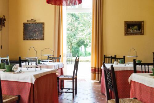 a dining room with tables and chairs and a window at Hotel Casona El Arral in Liérganes