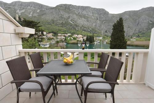 - une table avec un bol de fruits sur le balcon dans l'établissement Apartments Lorena, à Mokošica