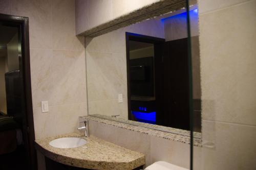 Motel Encuentro في تيخوانا: حمام مع حوض ومرآة