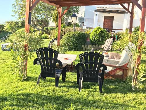 a group of chairs and a table in the grass at Casas El Molino in Vejer de la Frontera