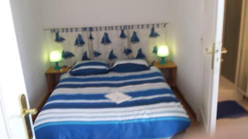 トレブールダンにあるResidence Bretagneのベッドルーム1室(青と白のベッド、ランプ2つ付)