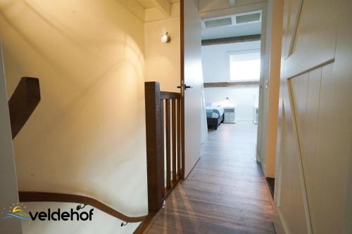 a hallway with a stairway leading to a room at 't Veldehof in Domburg