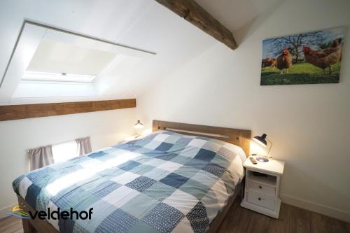 a bedroom with a bed and a window with chickens on the wall at 't Veldehof in Domburg