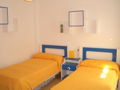 two beds in a room with yellow and blue at Primerísima línea de playa in Carboneras