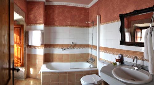 a bathroom with a tub and a toilet and a sink at Hotel Palacio Guevara in Treceño