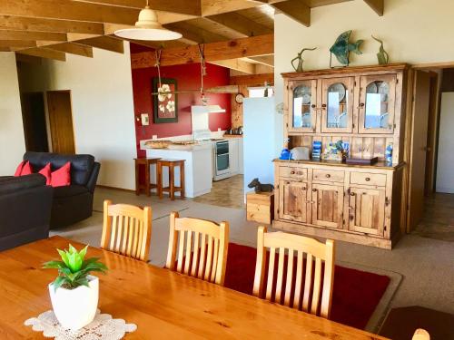 a living room and a kitchen with a table and chairs at Panoramic Drive Holiday House in Cape Bridgewater