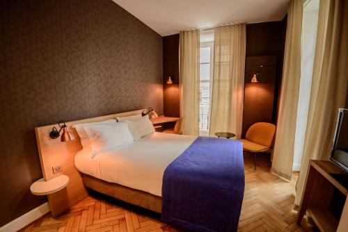 
a hotel room with a large bed and a large window at HANNONG Hotel & Wine Bar in Strasbourg
