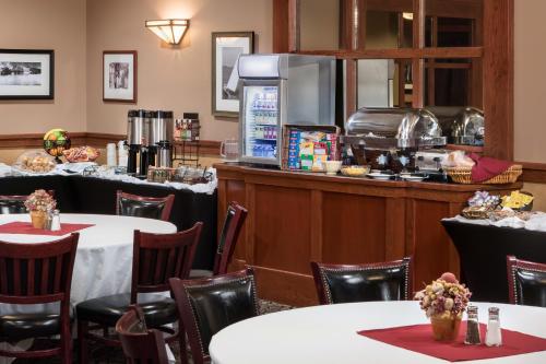 a dining room with tables and a counter at AmericInn by Wyndham Watertown in Watertown