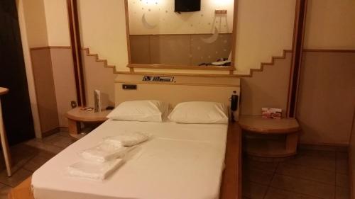 a room with a bed with two towels on it at America Motel (ADULT ONLY) in Vila Anastácio