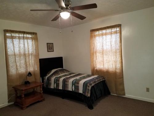 a bedroom with a bed and a ceiling fan at KY Lake Area Cabin in Aurora
