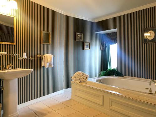 La salle de bains est pourvue d'une baignoire et d'un lavabo. dans l'établissement Waynebrook Inn, à Honey Brook