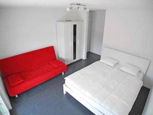 ein rotes Bett und ein rotes Sofa in einem Zimmer in der Unterkunft Casa Jorio App 9999 in Locarno