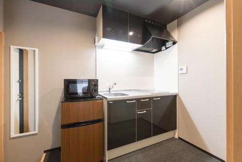 a small kitchen with a sink and a microwave at Stay SAKURA Kyoto Zen in Kyoto