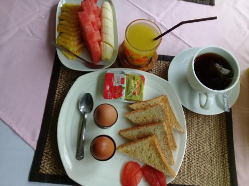 a plate with toast and eggs and a cup of coffee at Aonang Green Park Bungalow in Ao Nang Beach