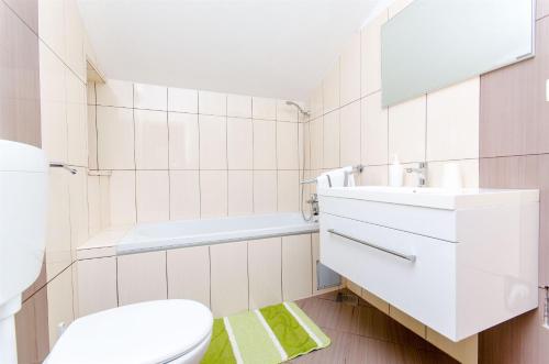 ein weißes Badezimmer mit Toilette und Waschbecken in der Unterkunft Apartments ANDREA in Mandre