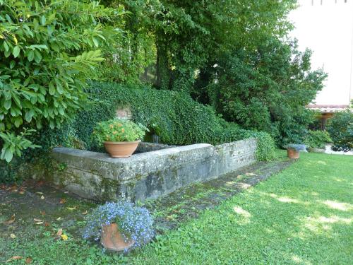 a garden with potted plants on a stone wall at La Rocca in Narni
