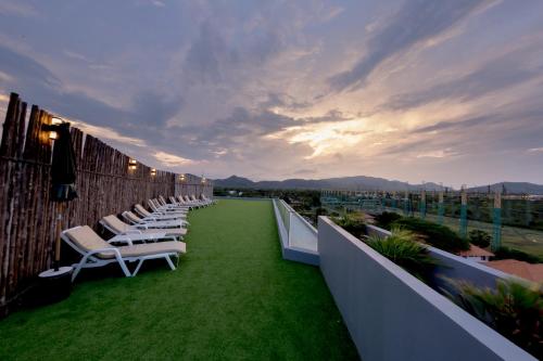 a row of lounge chairs on the roof of a building at Whale Hua Hin - SHA Plus in Hua Hin