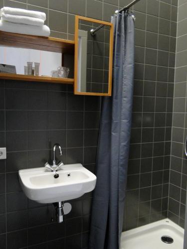 a bathroom with a sink and a shower curtain at LABnul50 self check-in hotel Groningen in Groningen