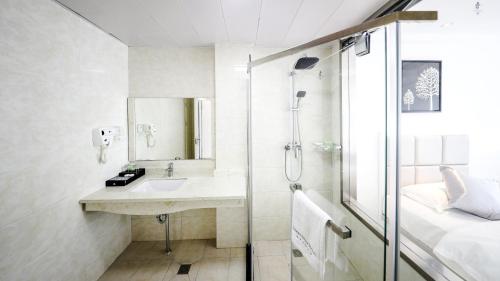 a bathroom with a sink and a shower at Ocean Star Hotel in Koror