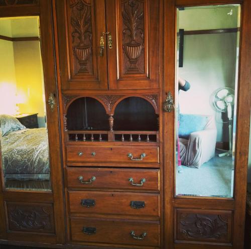 a wooden dresser with a mirror in a bedroom at Kinross Metcalfe Farm in Metcalfe