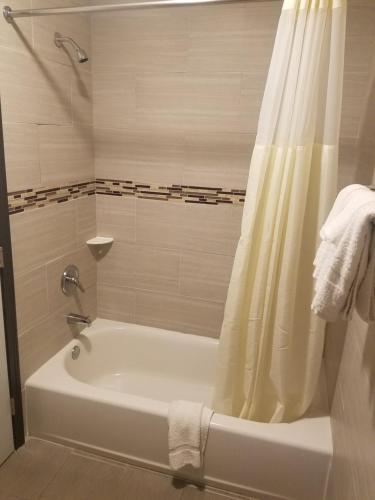 a bathroom with a bath tub with a shower curtain at Western Inn - Pensacola in Pensacola