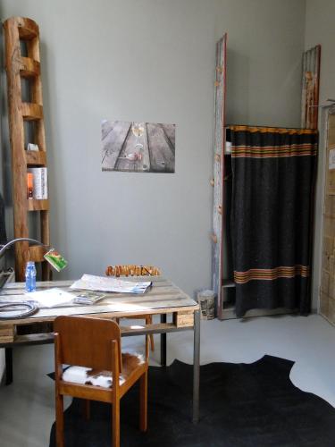a table and chairs in a room with a curtain at LABnul50 self check-in hotel Groningen in Groningen