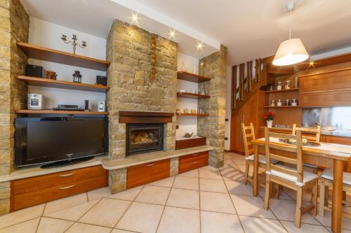 a living room with a fireplace and a television at CASA VACANZA Residence Lago di Endine in Monasterolo del Castello