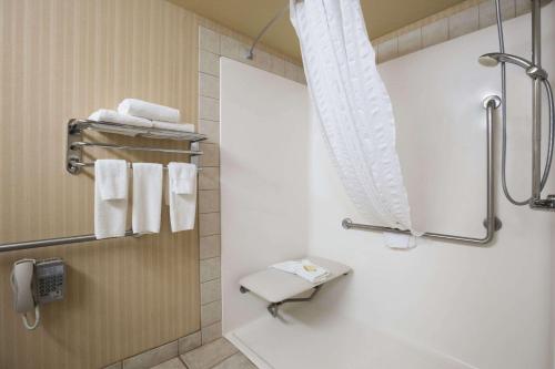 y baño con lavabo, aseo y toallas. en Super 8 by Wyndham Fort Nelson BC, en Fort Nelson