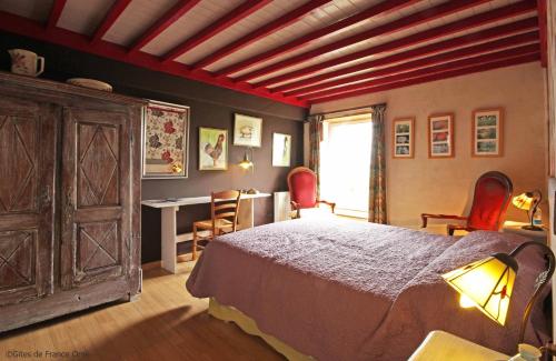 una camera da letto con un letto, un tavolo e delle sedie di Au Jardin Des Violettes a Mahéru