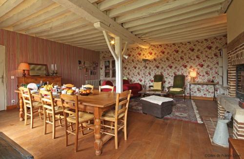 une salle à manger avec une table et des chaises en bois dans l'établissement Au Jardin Des Violettes, à Mahéru