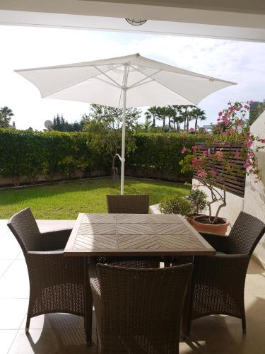 a table and chairs with an umbrella on a patio at Sunny Garden Limassol Star in Limassol