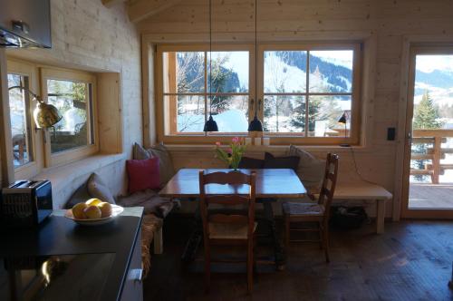 een eetkamer met een tafel en een aantal ramen bij Ski Chalet Nomad in Maria Alm am Steinernen Meer