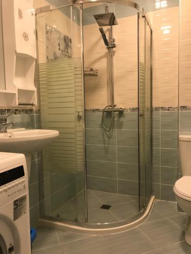 Un baño con ducha, inodoro y lavabo. en Orchid Studio, en Golden Sands