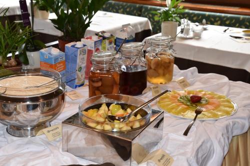 a table with a plate of food and a bowl of fruit at Angerburg Blumenhotel in Appiano sulla Strada del Vino