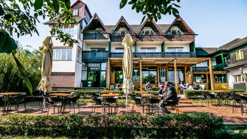 a man sitting at a table in front of a building at Pensiunea Belvedere in Tîrgu Neamţ