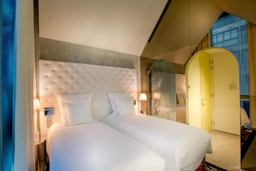 a bedroom with a large bed with white sheets at M Social Singapore in Singapore
