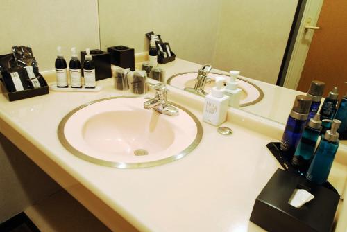 um balcão de casa de banho com um lavatório e um espelho em Hotel cooju Fukui em Sakai
