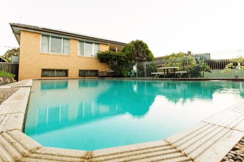 a large blue swimming pool in front of a house at Coal d' Vine VIEW - Cessnock NSW in Cessnock